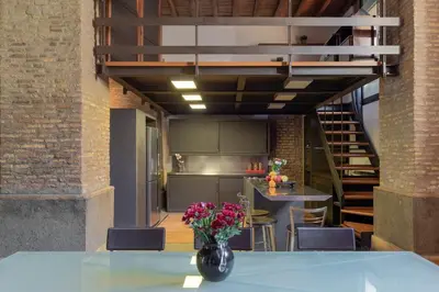 a kitchen with a table with a vase of flowers at Santa Cecilia Loft in Rome