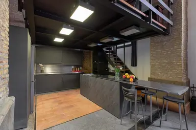 an industrial kitchen with a bar and a loft at Santa Cecilia Loft in Rome