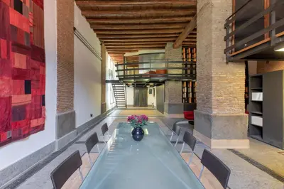 a dining room with a long table and chairs at Santa Cecilia Loft in Rome