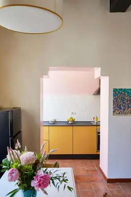 a kitchen with a vase of flowers on a table at TrastevereHome - Santa Maria della Quercia in Rome