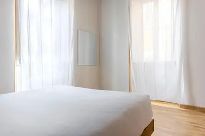 a bedroom with a white bed and a window at TrastevereHome - Santa Maria della Quercia in Rome