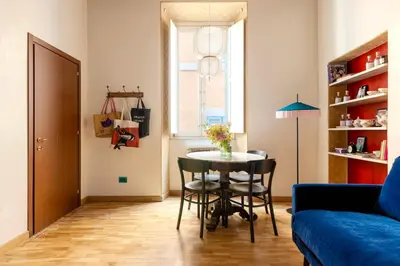 a living room with a table and a blue couch at TrastevereHome - Santa Maria della Quercia in Rome