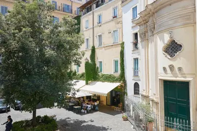 a woman walking past a building with a restaurant at TrastevereHome - Santa Maria della Quercia in Rome