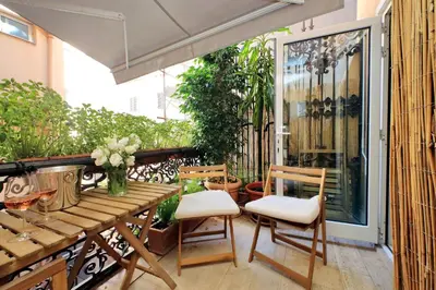 a patio with a wooden table and chairs at On The Steps in Rome
