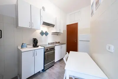 a small kitchen with white cabinets and a stove at Casa Riboty in Rome