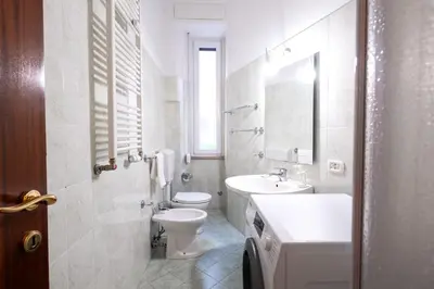 a white bathroom with a toilet and a sink at Casa Riboty in Rome
