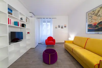 a living room with a yellow couch and a red chair at Casa Riboty in Rome