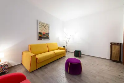 a living room with a yellow couch and a purple stool at Casa Riboty in Rome