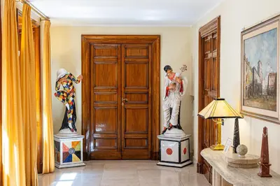 two statues of men standing in front of a door at TimeRoma Vatican in Rome