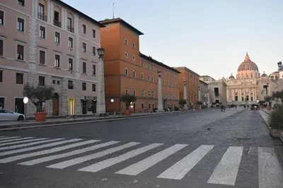 an empty street with a crosswalk in a city at TimeRoma Vatican in Rome