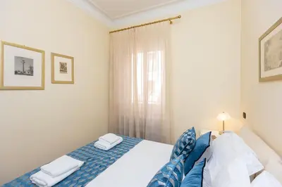 a bedroom with a bed with blue and white sheets at TimeRoma Vatican in Rome