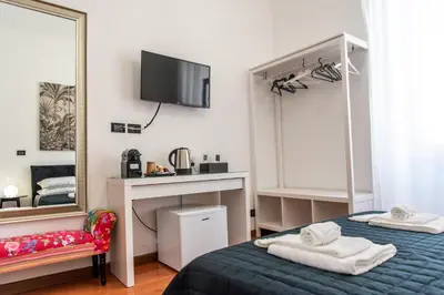 a bedroom with two beds and a mirror at Pura Vida in Rome