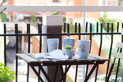 a wooden table with four cups on a balcony at Group Apartment Roma in Rome
