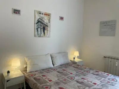 a bedroom with a bed with two tables and two lamps at Group Apartment Roma in Rome