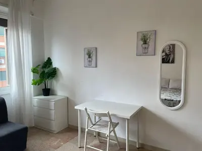 a white room with a table and a mirror at Group Apartment Roma in Rome
