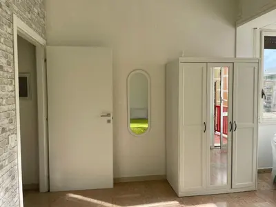 a white room with a door and a mirror at Group Apartment Roma in Rome