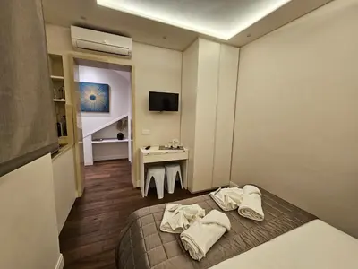 a hotel room with a bed and a desk at THE ONE FRATTINA Apartment in Rome