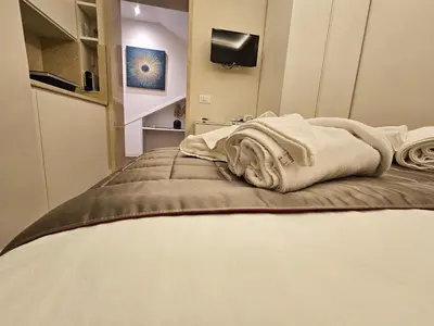 a room with a bed with towels on it at THE ONE FRATTINA Apartment in Rome