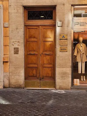 a wooden door on a building with a mannequin in a window at THE ONE FRATTINA Apartment in Rome