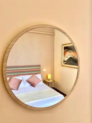 a bedroom with a bed and a round mirror at Upi-Up Rome Staying in Rome