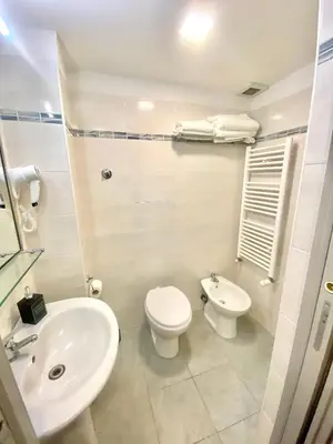 a white bathroom with a toilet and a sink at Upi-Up Rome Staying in Rome