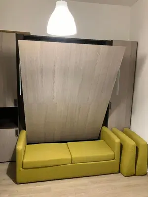 a yellow couch in a room with a ceiling at The Green House in Rome
