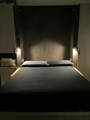 a bedroom with a large bed with two lights on it at The Green House in Rome