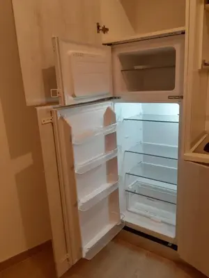 an empty refrigerator with its door open in a kitchen at The Green House in Rome