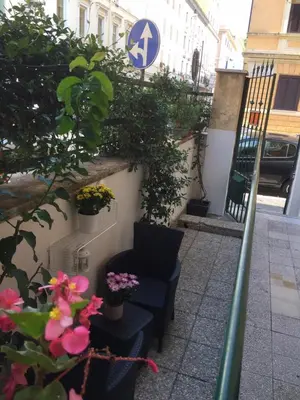 a stairway with two chairs and flowers and a sign at Roma Art Rooms in Rome