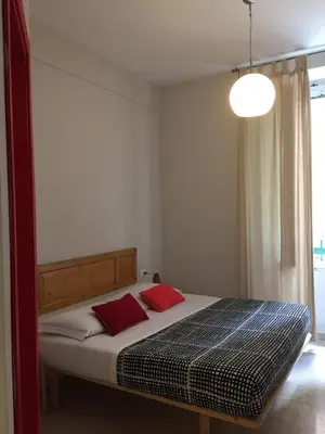 a bedroom with a bed with two red pillows at Roma Art Rooms in Rome