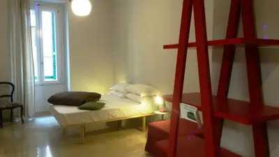 a small room with a bed and a red ladder at Roma Art Rooms in Rome