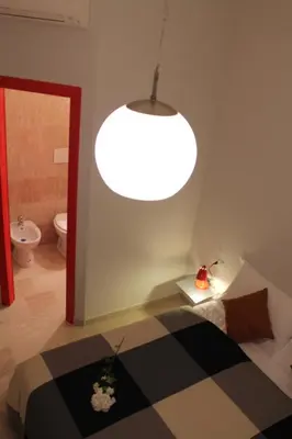 a room with a bed and a large light at Roma Art Rooms in Rome