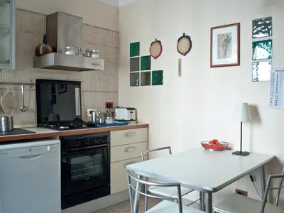 a kitchen with a table and a stove and a table and chairs at Minerva House in Rome