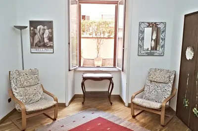 two chairs and a table in a room with a window at Minerva House in Rome