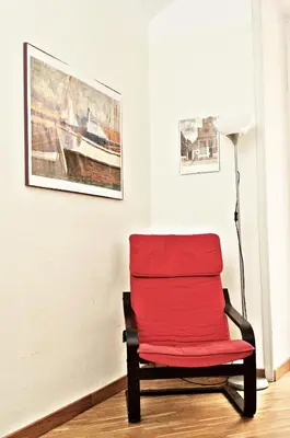 a red chair in a room with paintings at Minerva House in Rome