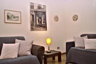 a living room with two couches and a table with a lamp at Minerva House in Rome