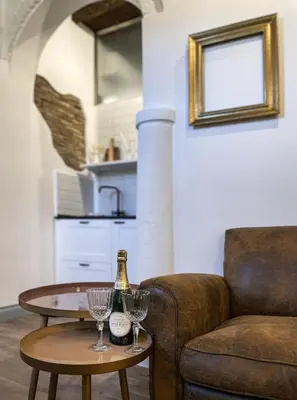 a living room with a couch and a table with wine glasses at DomusLu' - Casa di charme nel cuore di Roma in Rome