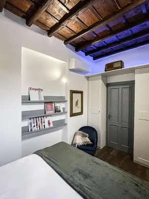 a bedroom with a bed and a chair at DomusLu' - Casa di charme nel cuore di Roma in Rome