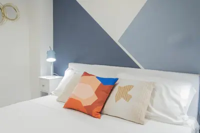 a white bed with two pillows on top of it at Nina - Tiny Suite in Trastevere in Rome