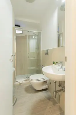 a bathroom with a toilet and a sink and a shower at Nina - Tiny Suite in Trastevere in Rome
