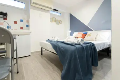 a bedroom with a bed with a blue blanket on it at Nina - Tiny Suite in Trastevere in Rome