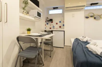 a small kitchen with a table and chairs in a room at Nina - Tiny Suite in Trastevere in Rome