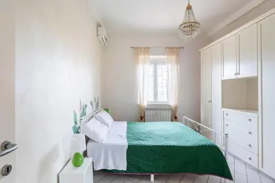 a bedroom with a green and white bed and a window at Appartamento per chi ama gustare il caffè in terrazzo in Rome