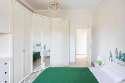 a bedroom with white cabinets and a green rug at Appartamento per chi ama gustare il caffè in terrazzo in Rome