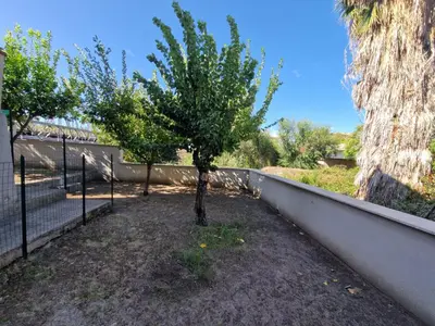 a tree in a yard next to a fence at Appartamento per chi ama gustare il caffè in terrazzo in Rome