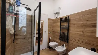 a bathroom with wooden walls and a toilet and a sink at casa vacanza vaticano in Rome