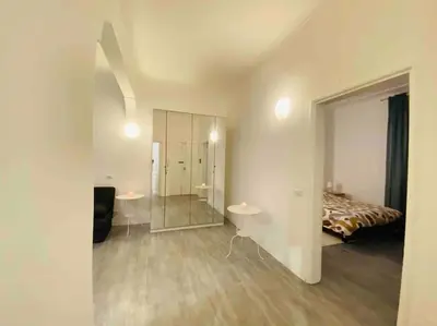 a bedroom with a bed and two tables and a mirror at Mamisà Rome, appartamento con parcheggio privato e gratuito in Rome