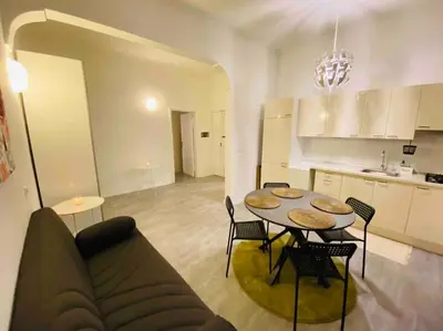 a living room with a table and a kitchen at Mamisà Rome, appartamento con parcheggio privato e gratuito in Rome