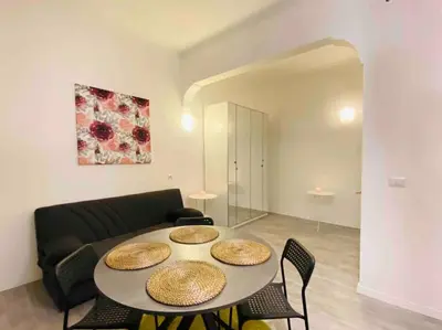 a living room with a table and a couch at Mamisà Rome, appartamento con parcheggio privato e gratuito in Rome