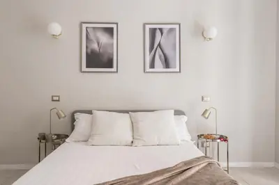 a bedroom with a bed with two pictures on the wall at The Best Rent - Bright flat near San Pietro in Rome